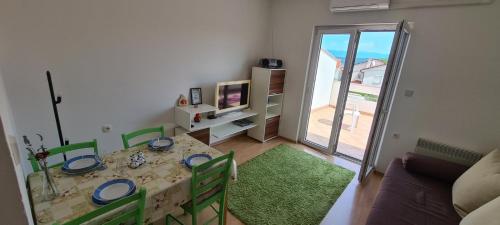 a living room with a table and chairs and a television at Apartments Porat in Porat