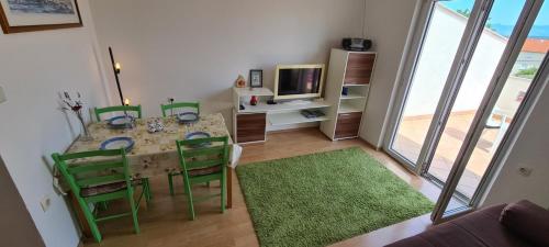 a dining room with a table and green chairs at Apartments Porat in Porat