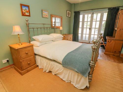 a bedroom with a bed and a lamp and a window at Easby Cottage in Richmond