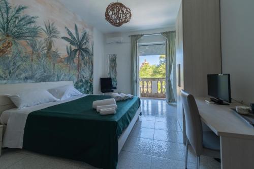 a bedroom with a bed with a desk and a television at Anime Bed&Breakfast in Siracusa