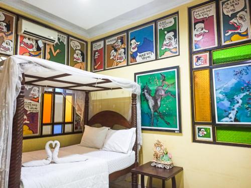 a bedroom with a bed and some pictures on the wall at Omah Eling Medang Kamulan Borobudur in Borobudur