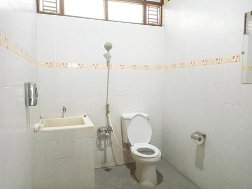 a white bathroom with a toilet and a sink at Omah Eling Medang Kamulan Borobudur in Borobudur