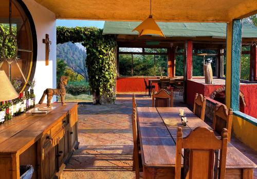 d'une salle à manger avec une table, des chaises et une fenêtre. dans l'établissement Rancho EL PARAÍSO AJUSCO, à Mexico