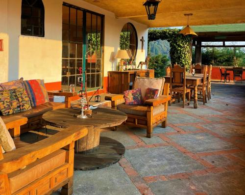 a patio with wooden furniture and a table and chairs at Rancho EL PARAÍSO AJUSCO in Mexico City