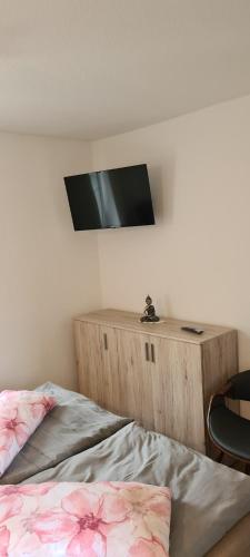 a bedroom with a bed and a television on a wall at Meyers gemütliche Ferienwohnung in Altglietzen
