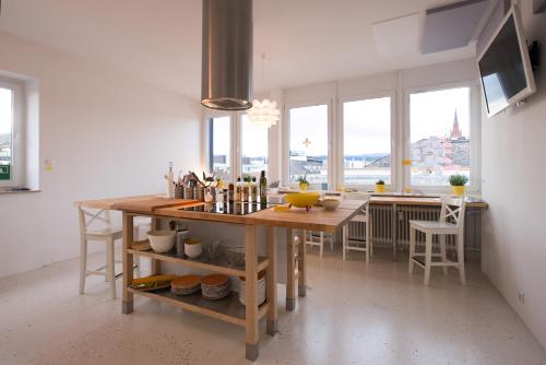 a kitchen with a wooden table and some windows at Business Hostel Wiesbaden ONE in Wiesbaden