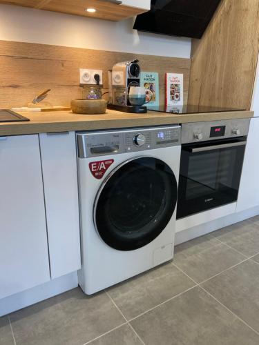 a kitchen with a washing machine and a counter at Le Denecourt - à deux pas de la Gare et de la Forêt de Fontainebleau in Avon