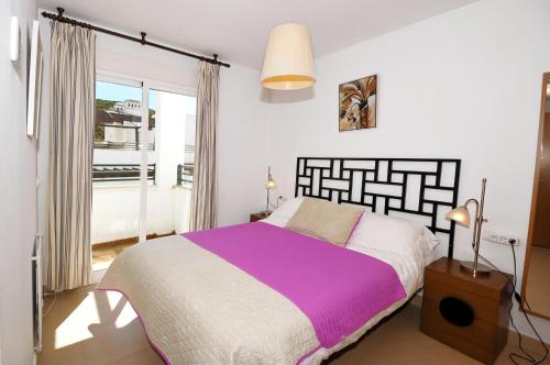 Un dormitorio con una cama grande y una ventana en 3 Bedroom Townhouse Benahavis Village, en Benahavís