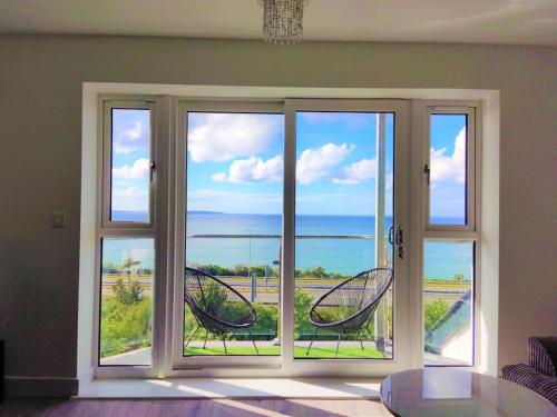 a room with a window with a view of the ocean at Modern apartment with breathtaking sea views in Penmaen-mawr