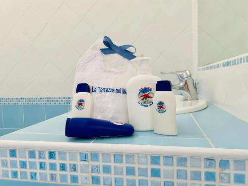 a bathroom counter with two bottles of detergent and a sink at La Terrazza nel Mare in Acciaroli