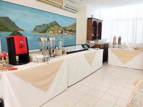 a kitchen with white counters and a painting on the wall at Hotel Electra in Tolo