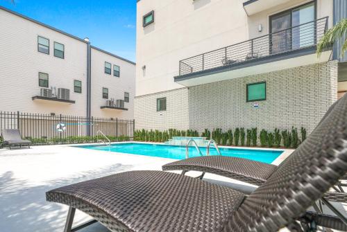 a patio with two chairs and a swimming pool at New Construction Elegant Villas in New Orleans