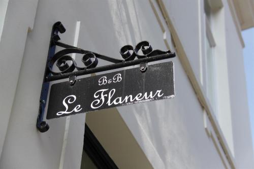 a sign hanging on the side of a building at B&B Le flaneur in Bruges