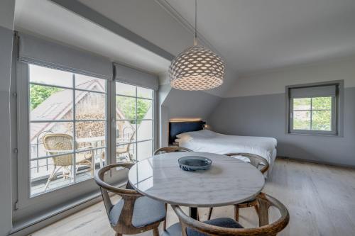 a room with a table and chairs and a bed at Villa Magnolia in Oostkapelle