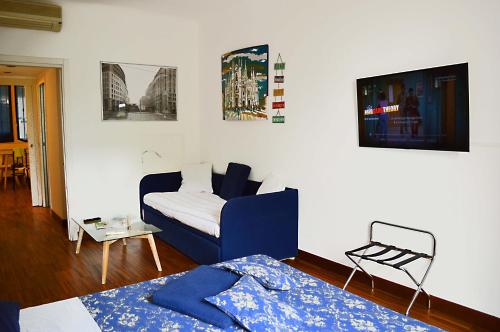 een slaapkamer met een bed en een bank erin bij Room Inn in Milaan