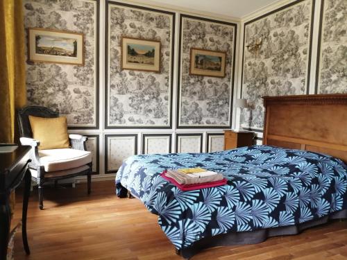 1 dormitorio con cama, silla y papel pintado en Chambre Le Notre Le Domaine Des Jardins De Bracquetuit, en Bracquetuit