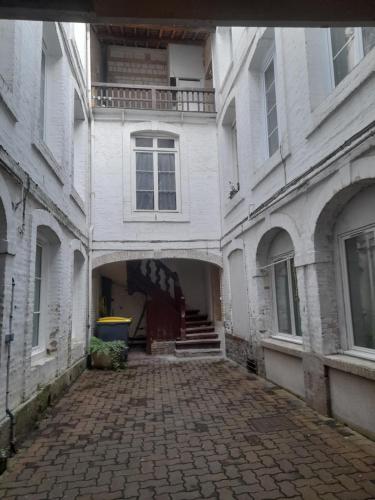 Une allée vide dans un vieux bâtiment blanc dans l'établissement La clef du cocon dieppois, à Dieppe