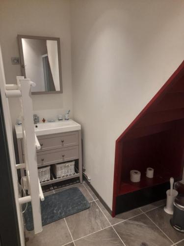 a bathroom with a sink and a mirror at Appartement de l'épée in Dieppe