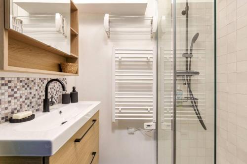 a bathroom with a shower with a sink and a glass shower door at Chic 2BR in city center, next to Train Station in Chamonix
