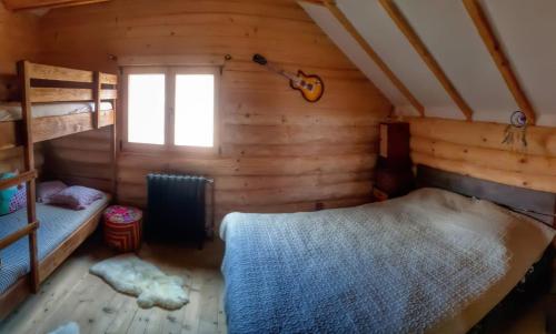 a bedroom with two bunk beds and a guitar at Casutele din Livada in Corbi