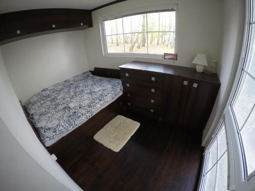 ein Schlafzimmer mit einem Bett, einer Kommode und einem Fenster in der Unterkunft Wiosna nad jeziorem, grill, ognisko in Barkowice