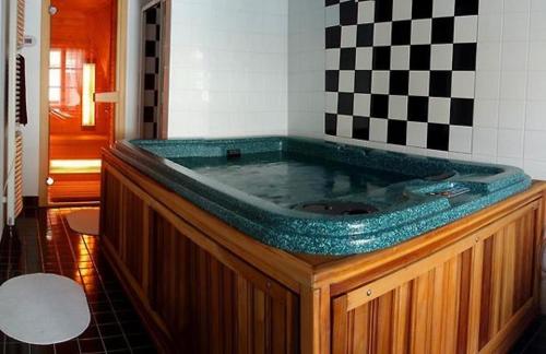 una gran bañera de hidromasaje en una habitación con una pared a cuadros en Apartmán RAST, en Třebíč