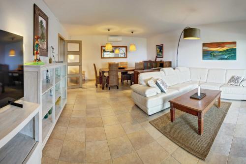 a living room with a white couch and a table at VILLA LA CALA with swimming pool & sea view, 10 min walk from the sea in Blanes