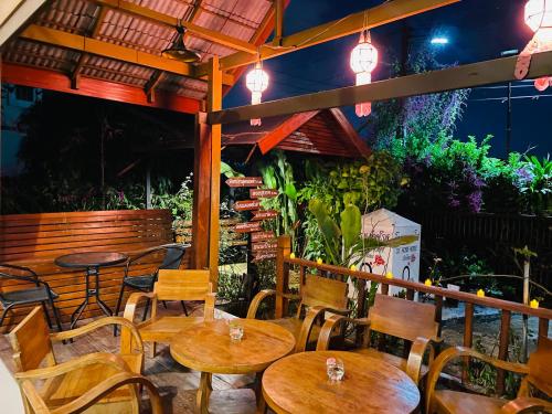 un restaurante con mesas de madera, sillas y luces en DE ROSE Hotel Chiang Mai, en Chiang Mai