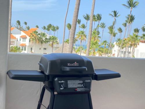 a grill in front of a wall with palm trees at Stanza Mare Beach Front in Punta Cana