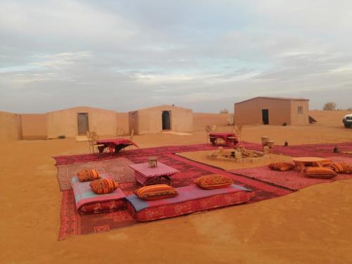 eine Gruppe von Zelten inmitten einer Wüste in der Unterkunft Chigaga Luxury Camp in M’hamid El Ghizlane