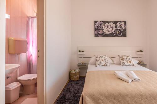 a small bedroom with a bed and a toilet at Family Apartments Jadrijević in Primošten
