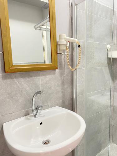 a bathroom with a sink and a mirror and a shower at Windrose Hostel Istanbul in Istanbul