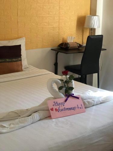 a hotel room with a happy anniversary sign on a bed at DE ROSE Hotel Chiang Mai in Chiang Mai