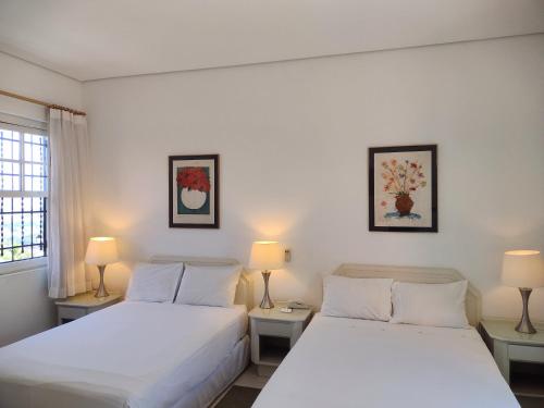 two beds in a room with two lamps at Varandas da Montanha in Carmo do Rio Claro