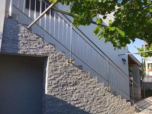 a set of stone stairs with a metal railing at Apartman Josipa in Peroj