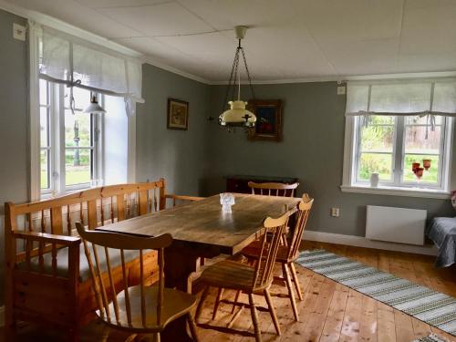 - une salle à manger avec une table et des chaises en bois dans l'établissement Fråsttorp, à Aneby