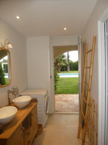 een badkamer met twee wastafels en een deur naar een tuin bij Ramatuelle, Pampelonne, villa in Saint-Tropez
