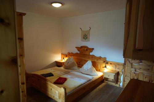 a bedroom with a wooden bed in a room at Hainererhof in Mauterndorf