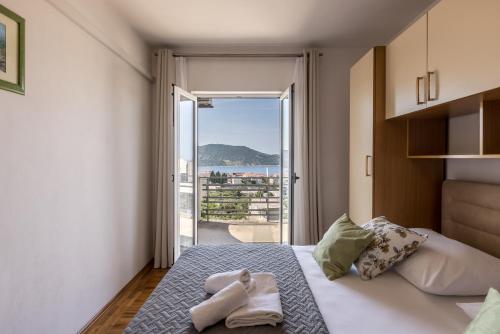 a bedroom with a bed with a view of the ocean at Family Apartments Jadrijević in Primošten