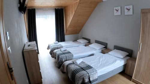 sypialnia z 3 łóżkami w pokoju w obiekcie Willa Trzy Podkowy w Krościenku