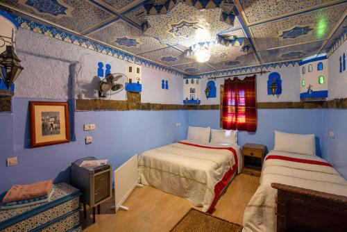 2 camas en una habitación con paredes azules en Casa La Hiba en Chefchaouene