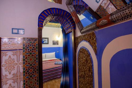 a bedroom with a mirror and a bed in a room at Casa La Hiba in Chefchaouene