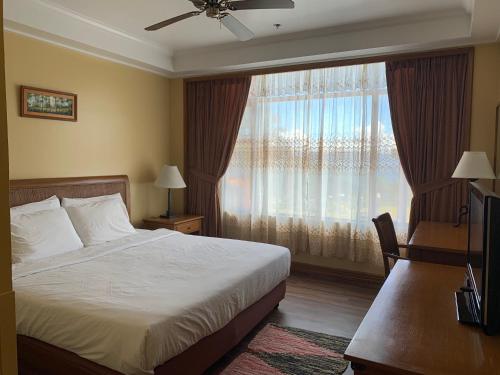 a bedroom with a bed and a large window at The Manor Hotel Baguio Private Unit Superior Room with Garden View in Baguio