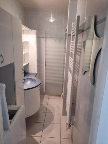 une salle de bain blanche avec des toilettes et un lavabo dans l'établissement Au Barcarès, vue magnifique sur le port et la mer, au Barcarès