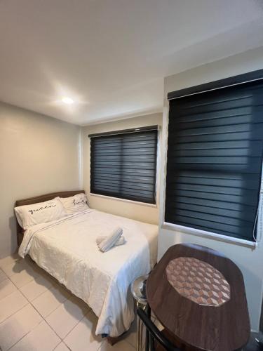 - une chambre avec un lit et 2 fenêtres avec des stores dans l'établissement Cozy Boo Staycation near Enchanted kingdom by Dynel, à Santa Rosa
