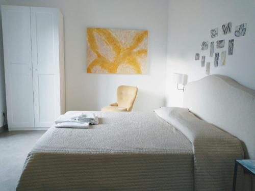 una camera bianca con un letto e una sedia di Angeli di terra a Salerno