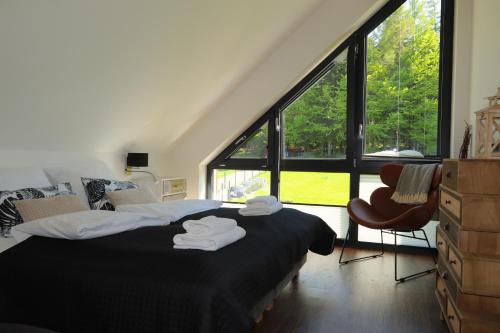 una camera da letto con un letto e una grande finestra di Domy Pod Babią a Zawoja