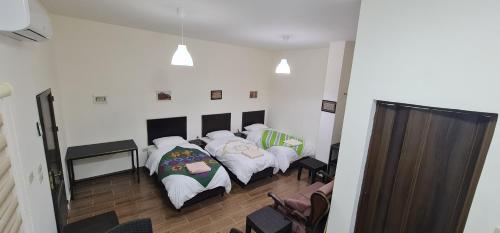 two beds in a room with a mirror at GMT Residence in Madaba