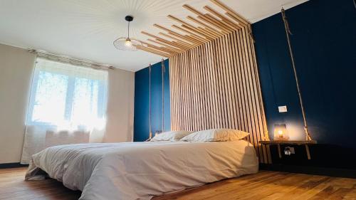 1 dormitorio con 1 cama grande y pared azul en Sleep & Road, en Couteuges