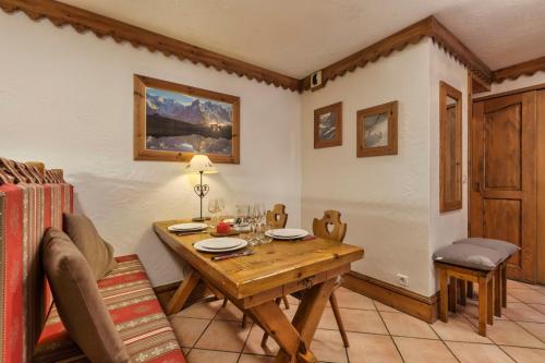 une salle à manger avec une table et des chaises en bois dans l'établissement Grepon -City Center - Free Swimming pool, Sauna, Gym - Free Parking - By Cozee Rentals, à Chamonix-Mont-Blanc